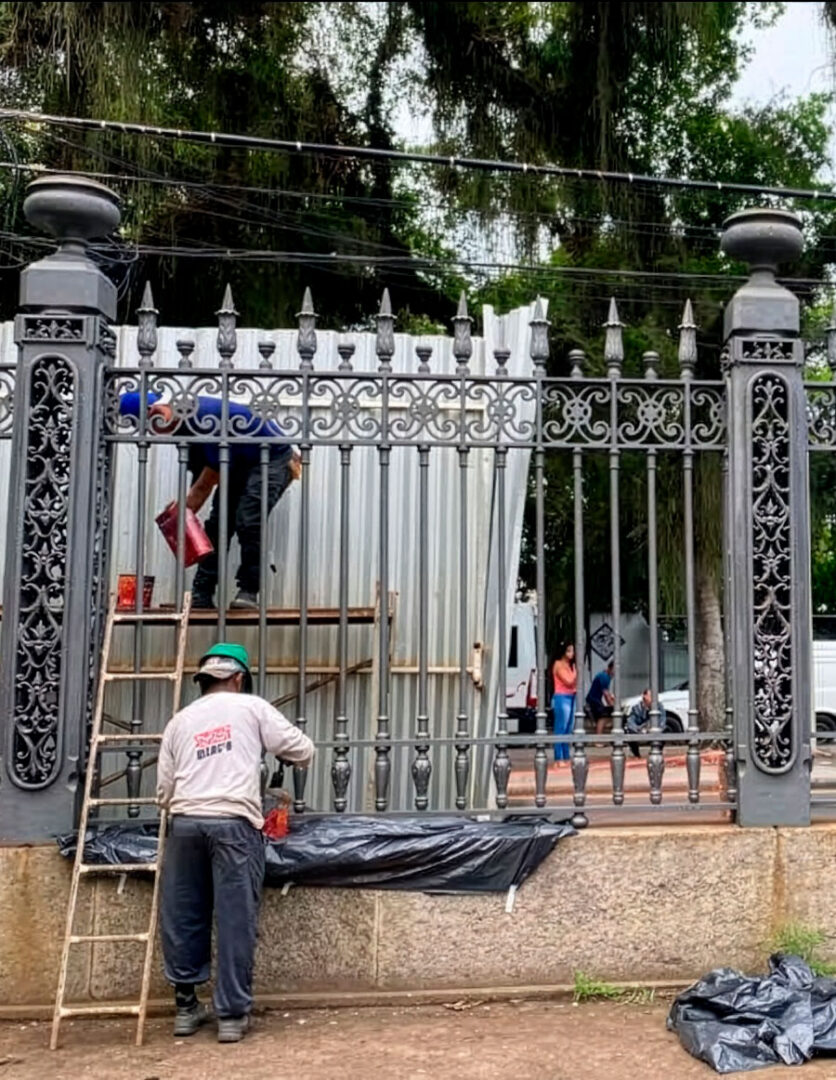 Trabalhadores restaurando o gradil.